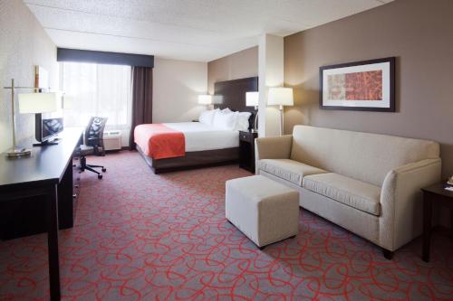 a hotel room with a bed and a couch at Holiday Inn Express & Suites Bloomington West by IHG in Bloomington