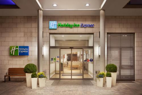 a hospital entrance with potted plants in front of a building at Holiday Inn Express Nürnberg-Schwabach in Schwabach