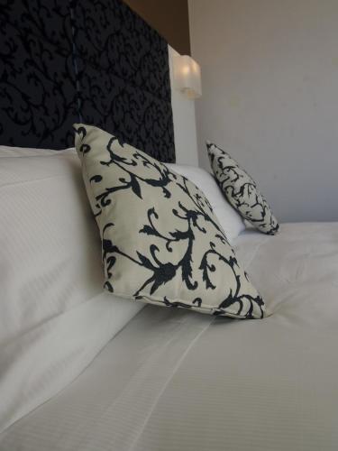 a bed with a black and white pillow on it at Best Western Hotel Acqua Novella in Spotorno