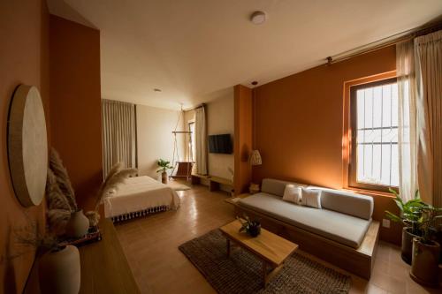a living room with a couch and a bed at Casa Montore by Barrio Mexico in Guadalajara