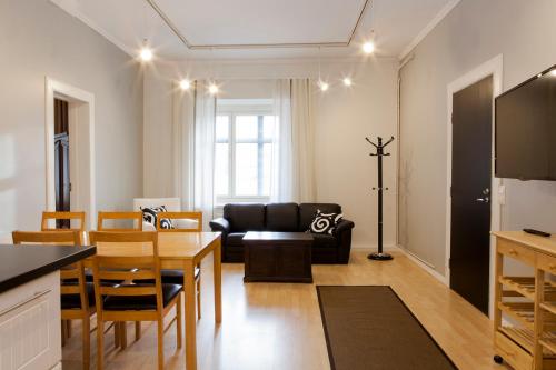 - un salon avec un canapé noir et une table dans l'établissement Hotelli Ville Apartment, à Tampere