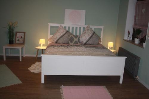 um quarto com uma cama branca com almofadas em Ferienwohnung Nink em Boppard
