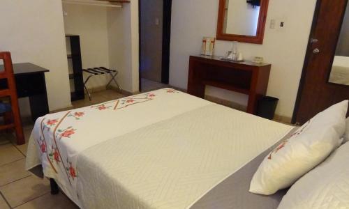 a bedroom with a large white bed with flowers on it at Hotel San Miguel Penjamo in Pénjamo