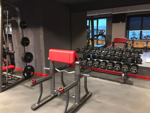 a gym with a red bench and lots of dumbbells at Zlatibor apartman Chill out in Zlatibor