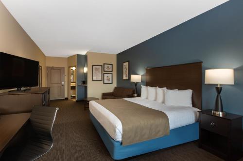a hotel room with a bed and a flat screen tv at AmericInn by Wyndham Sioux Falls North in Sioux Falls