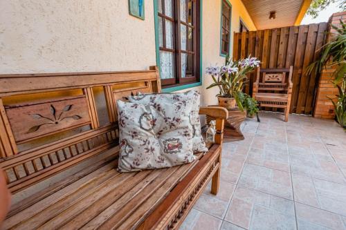 a wooden bench with a pillow on a porch at Pousada Santa Genoveva campeche in Florianópolis