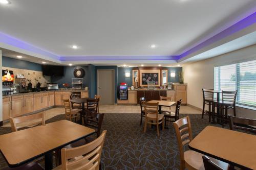 a restaurant with tables and chairs and a kitchen at AmericInn by Wyndham Sioux Falls North in Sioux Falls