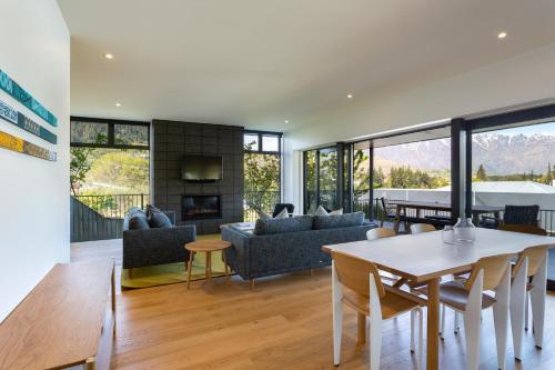 a living room with a table and a dining room at Waipatiki by Sotheby's Luxury Rental Homes in Queenstown
