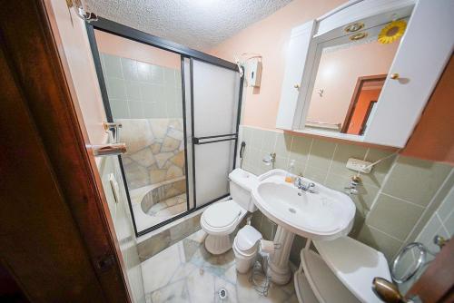 a bathroom with a toilet and a sink and a shower at Casa de Mármol in Riobamba