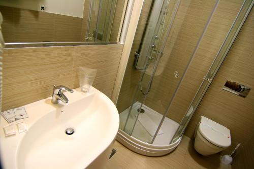 a bathroom with a sink and a shower and a toilet at Hotel Crystal in Sarajevo