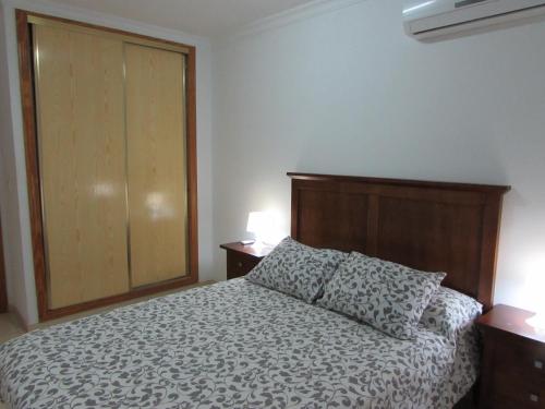 加魯查的住宿－Garrucha Apartment，一间卧室配有一张带木制床头板的床