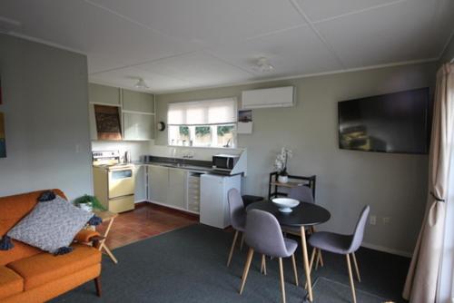 ハンマー・スプリングスにある3 Woodbank Roadのテーブルとキッチンのあるリビングルーム