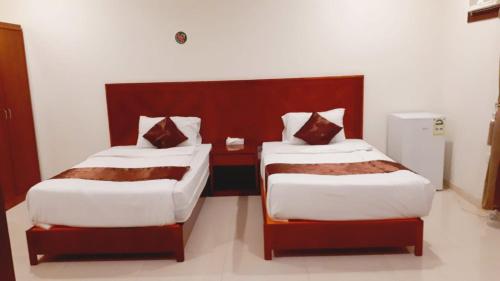 two beds in a hotel room withskirts at Iwan Alandalusia Al Ajaweed in Jeddah