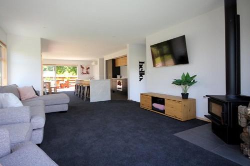 a living room with a couch and a tv at 15 Hepburn Lane in Hanmer Springs