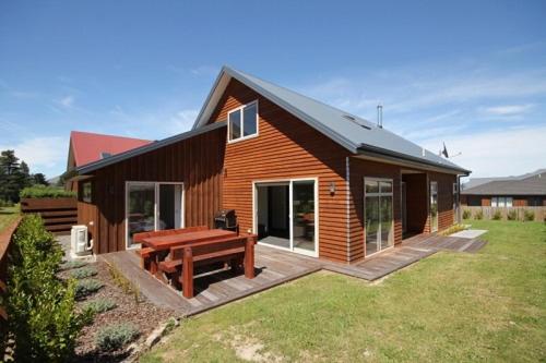 a log cabin with a picnic table in the yard at 15 Hepburn Lane in Hanmer Springs
