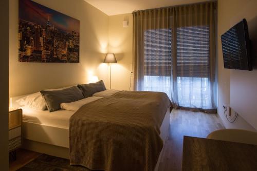 a bedroom with a bed and a large window at Premium Apartment München Messe in Munich