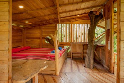 a bedroom of a log cabin with a bed in it at River Side Cabana in Tissamaharama