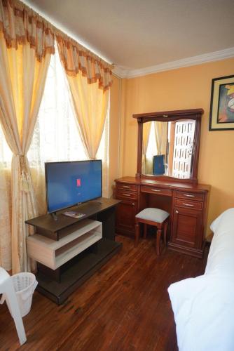 a bedroom with a desk and a bed and a mirror at Casa de Mármol in Riobamba