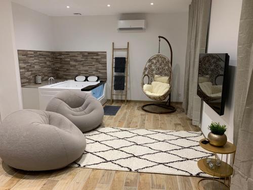 a living room with a couch and a chair and a sink at Appartement Cosy Jacuzzy Luxe Gare de Toulon in Toulon