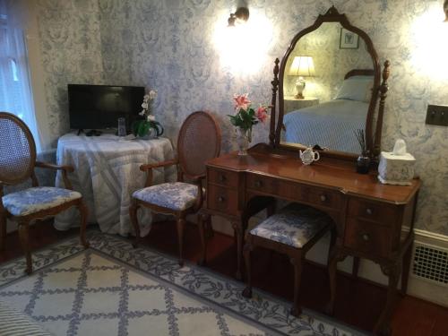 a bedroom with a bed and a dresser and a mirror at Briar Rose Inn Vancouver WA USA in Vancouver