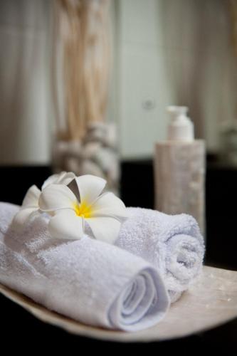 a plate with towels and flowers on a table at Blue Marine Resort in Gili Islands