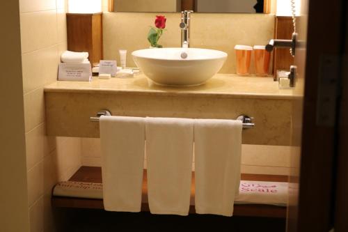 a bathroom with a sink and towels on a counter at Crowne Plaza Sohar by IHG in Sohar