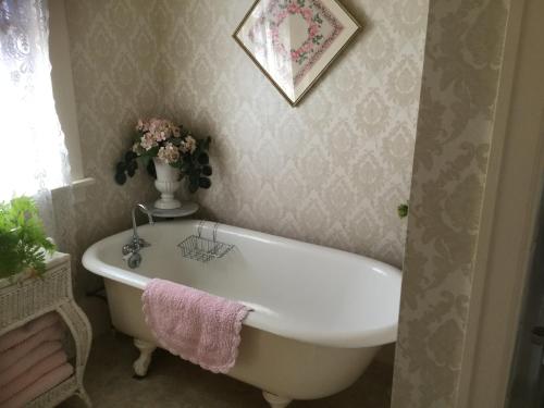 a bathroom with a white bath tub and a vase of flowers at Briar Rose Inn Vancouver WA USA in Vancouver
