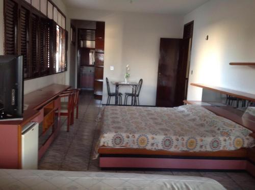 a bedroom with a bed and a table with chairs at Casa Verde Albuquerque in Fortaleza