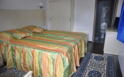 a bedroom with a bed with a colorful bedspread at Complex Domneasca in Seimeni