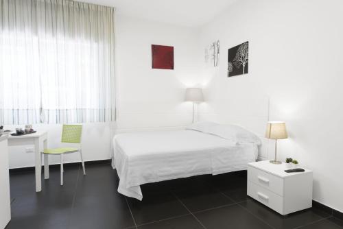 Habitación blanca con cama, escritorio y silla en Acquaviva Apartments, en Nápoles