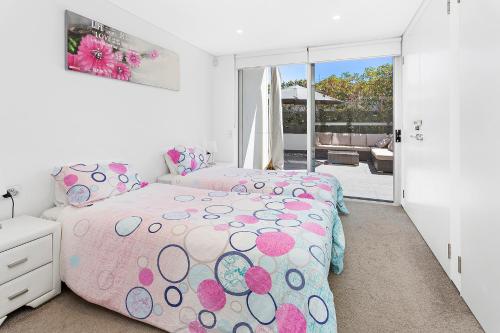 基亞馬的住宿－Kiama Seaside Getaway，卧室配有粉红色的床和波卡圆点