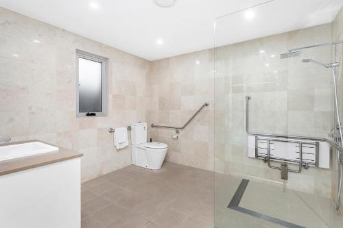 a bathroom with a shower and a toilet and a sink at Kiama Seaside Getaway in Kiama
