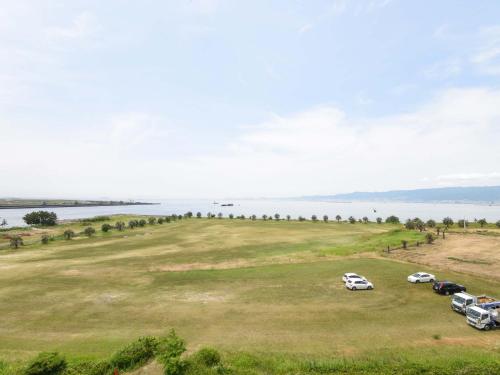 a group of cars parked in a field next to the water at The Day Osaka in Osaka
