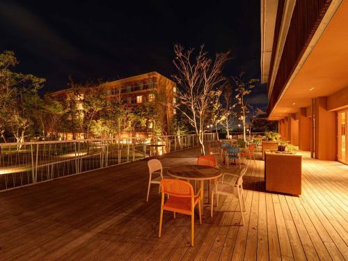 a wooden deck with a table and chairs and a building at The Day Osaka in Osaka