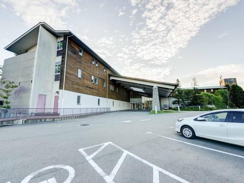 a car parked in a parking lot in front of a building at The Day Osaka in Osaka