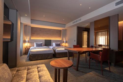 a hotel room with two beds and a table at Tokyu Stay Kyoto Sakaiza Shijo Kawaramachi in Kyoto