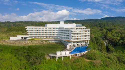 - un grand bâtiment avec une piscine en face dans l'établissement Hidden Cliff Hotel and Nature, à Seogwipo