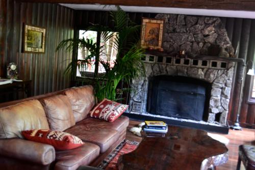 a living room with a couch and a stone fireplace at Guerneville Lodge in Guerneville