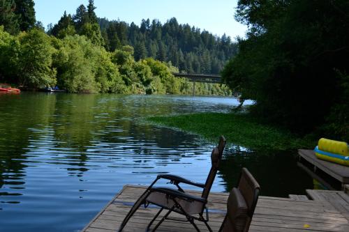 a chair sitting on a dock next to a lake at Guerneville Lodge in Guerneville