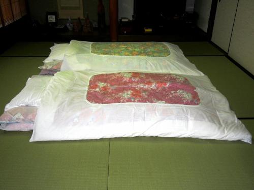 En eller flere senge i et værelse på 古民家民宿 麻の宿