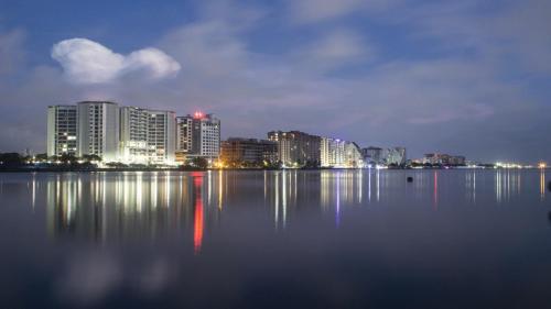 a city skyline with a large body of water at night at Holiday Inn Cochin by IHG in Cochin