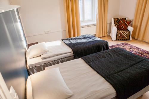 タンペレにあるHotelli Ville Apartmentのベッド2台と椅子が備わる客室です。