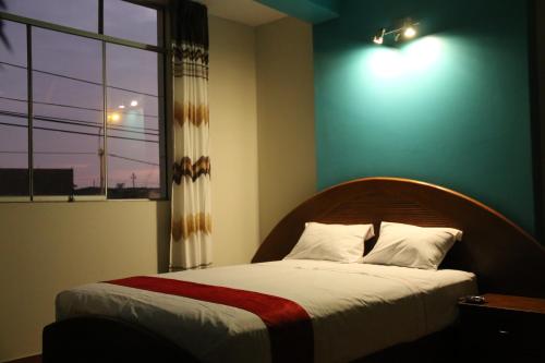 钦博特Hotel Camino Real的一间带大床的卧室，带窗户