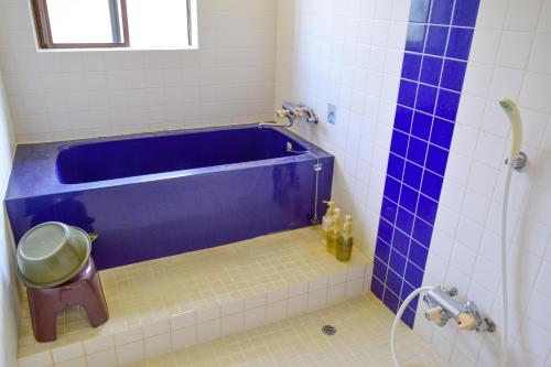 a blue tub in a bathroom with a shower at Sea Tiger Island Inn Shodoshima in Shodoshima