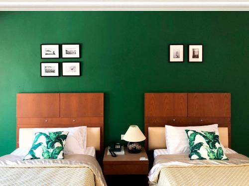 Dormitorio verde con 2 camas y pared verde en Tonwa Resort Hotel, en Khon Kaen