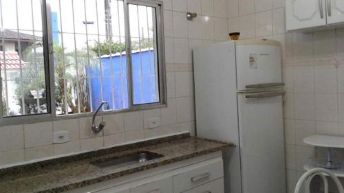 uma cozinha com um frigorífico, um lavatório e uma janela em Casa temporada na praia em Ubatuba