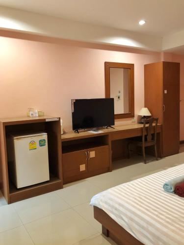 a bedroom with a desk with a computer and a television at Tonwa Resort Hotel in Khon Kaen