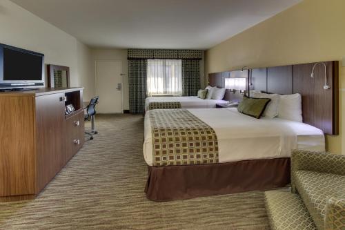 a hotel room with two beds and a flat screen tv at The Stevenson Monterey in Monterey
