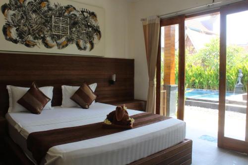 a bedroom with a bed and a sliding glass door at Singabu Bungalows in Nusa Penida