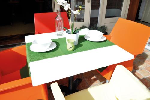 a white table with plates and a bottle on it at City Hotel Koningsvlinder in Veenendaal